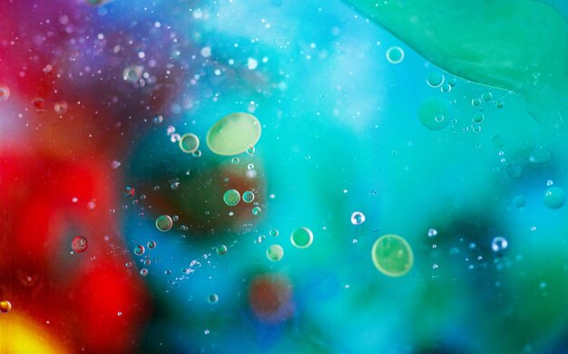 Des gouttes d'huile verte sur un liquide multicolore