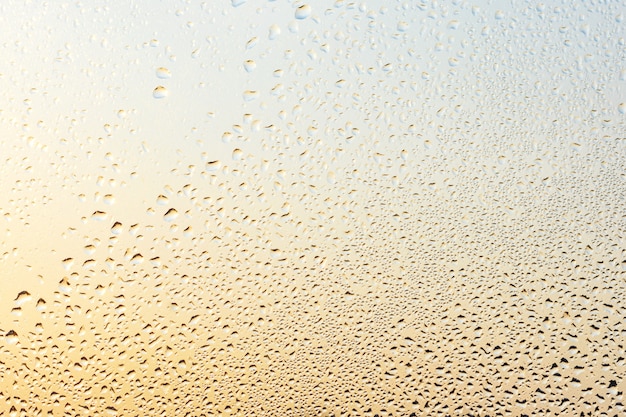 Gouttes de pluie et eau gelée sur fond de verre de fenêtre