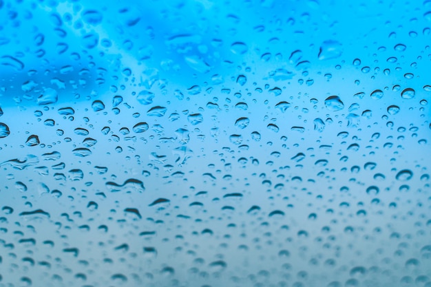 Gouttes de pluie sur la fenêtre Gouttelettes d'eau sur le verre Ton bleu