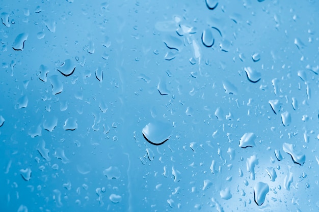 Gouttes de pluie sur la fenêtre. Ton bleu