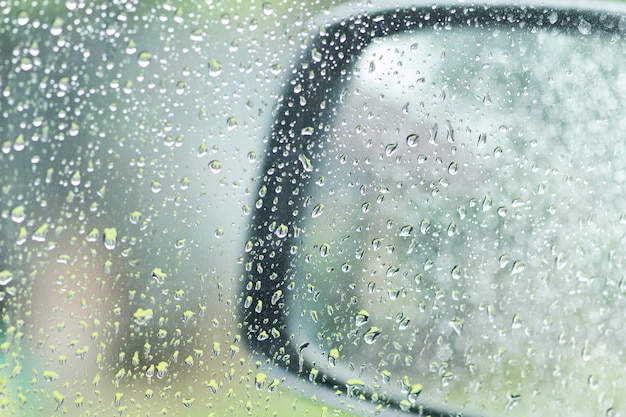 Gouttes de pluie sur la fenêtre de la voiture et miroir de la voiture un jour de pluie