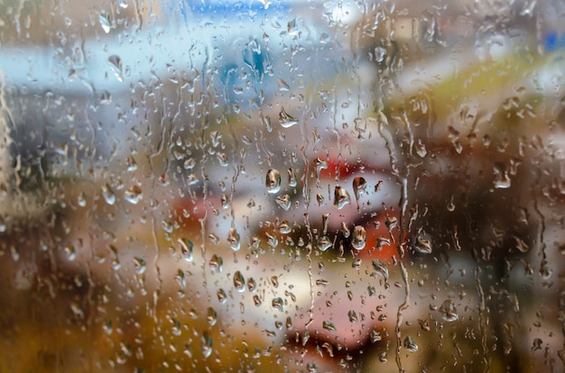 Gouttes de pluie sur le fond de la fenêtre de la rue