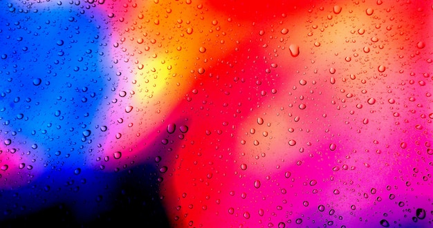 Gouttes de pluie sur fond de fenêtre en verre coloré.