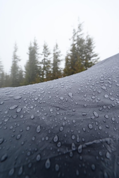 Gouttes de pluie sur un gros plan de tente bleue Matin brumeux dans les Carpates