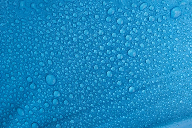 Gouttes de pluie sur un parapluie bleu.