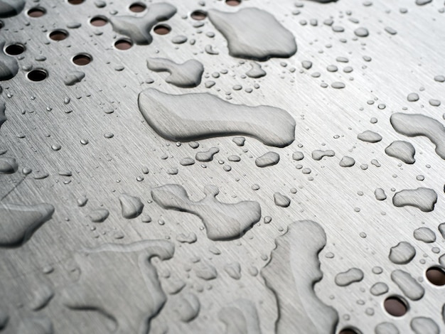 Gouttes de pluie photo en gros plan sur une surface métallique polie d'un banc