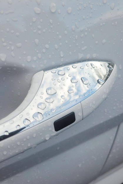 Photo gouttes de pluie sur une poignée de porte de voiture