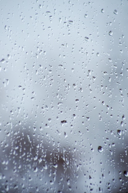 Gouttes de pluie sur la surface des verres de fenêtre avec bokeh.