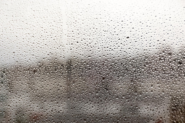 Gouttes de pluie sur le verre sur un arrière-plan flou pluie sur la fenêtre pluie dégoulinante sur la photo de texture de fenêtre