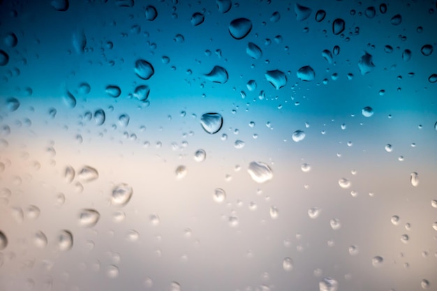 Gouttes de pluie sur le verre de la fenêtre à l'extérieur de l'eau de fond de texture de merveilleux