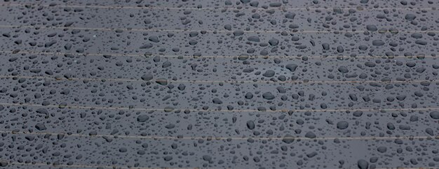 Gouttes de pluie sur le verre de voiture accumulation d'eau sur une surface lisse