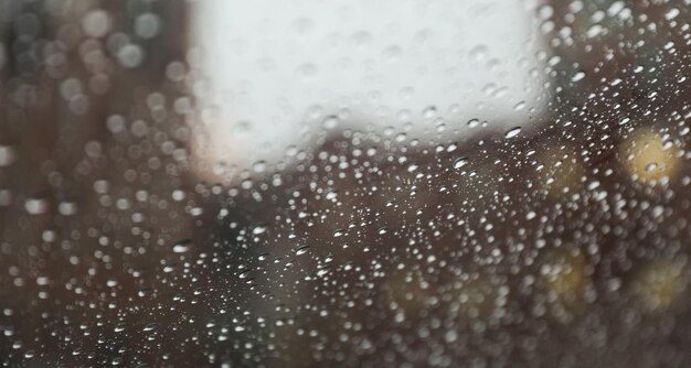 Gouttes de pluie sur la vitre pendant une journée pluvieuse capturant la tranquillité et la mélancolie du thé de la nature