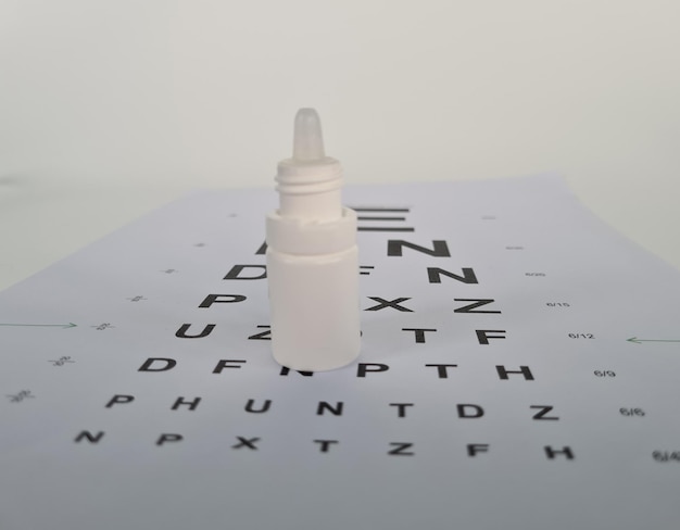 Photo gouttes pour les yeux sur fond de table pour tester l'acuité visuelle