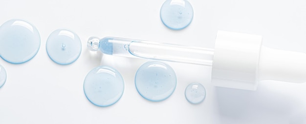 Photo gouttes de sérum cosmétique et une pipette un produit de soin de la peau fond blanc