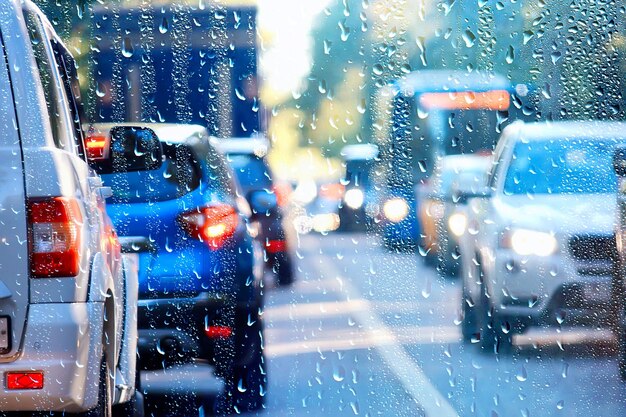 gouttes sur verre auto route pluie automne nuit / abstrait automne fond dans la ville, circulation automobile, voyage romantique en voiture