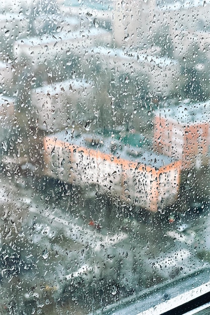 Les gouttes sur le verre par temps nuageux pluvieux évoquent la mélancolie et la tristesse Vue de la ville depuis la fenêtre