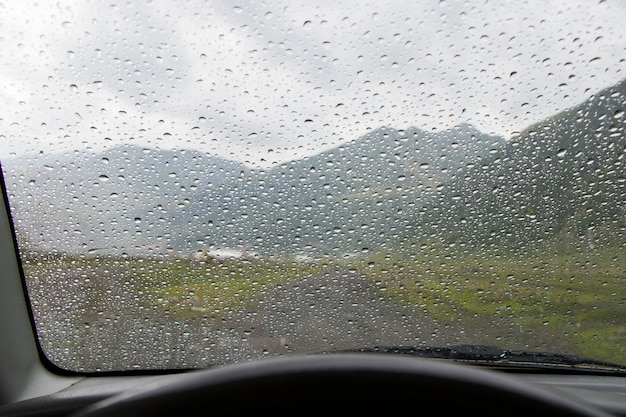 Gouttes sur le verre de la voiture et le fond du paysage de montagne