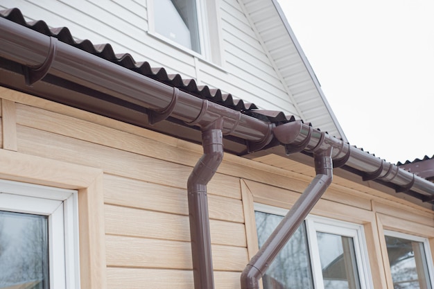 Photo gouttière avec tuyau de descente sur le toit d'une maison.