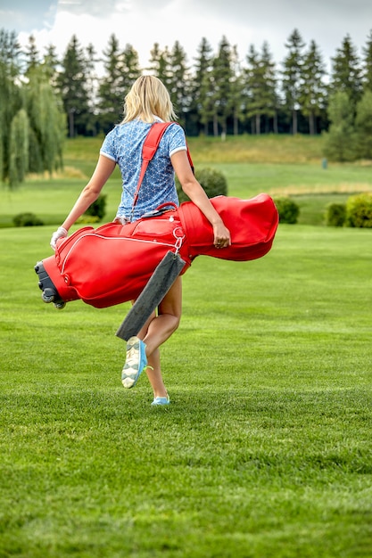 GoWomen golfant un équipement de golf sur un champ vert