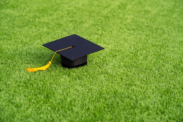 Graduation Chapeau noir et pas de pompon jaune sur champ vert