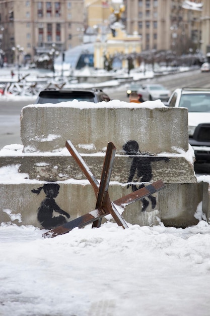 Graffiti Banksy à Kyiv. Stencil - les enfants montent sur un hérisson antichar comme sur une balançoire.