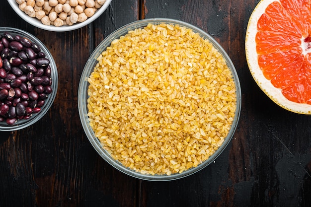 Grain de boulgour dans un bol et ingrédients frais