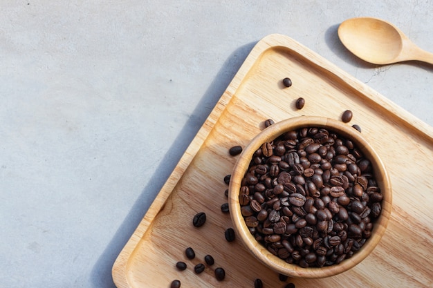 Grain de café dans une tasse en bois sur fond de bureau