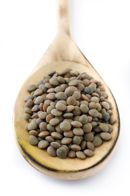 Grain de lentilles sur une cuillère en bois isolé