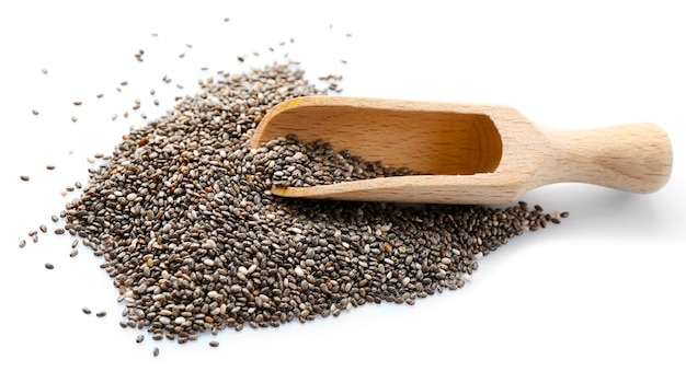 Graines de chia dans une cuillère en bois isolée sur une surface blanche