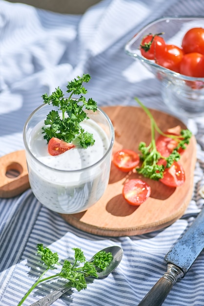 Graines de chia et yogourt dans un verre avec des légumes verts et des tomates