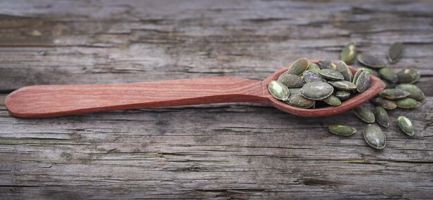 Graines de citrouille grillées et salées sur une surface en bois