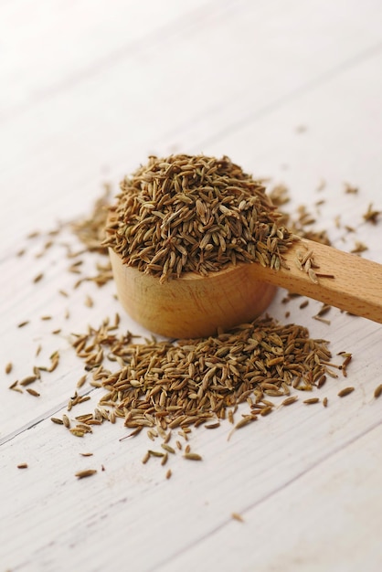 Graines de cumin sur cuillère sur table close up