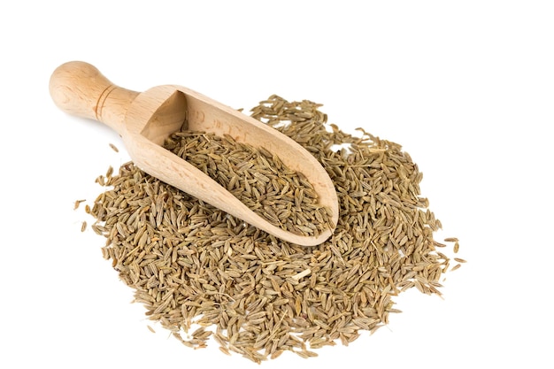 Graines de cumin dans une cuillère pour épices isolé sur fond blanc