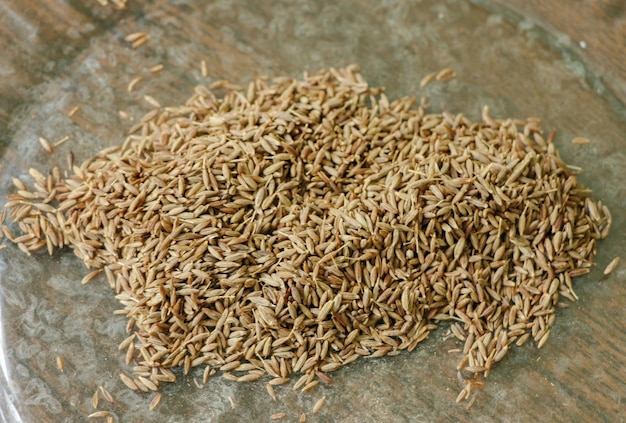 Graines de cumin Jeera dans une assiette sur le fond en bois