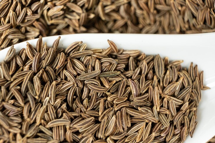 Photo des graines entières de cumin carum carvi l en gros plan en cuillère