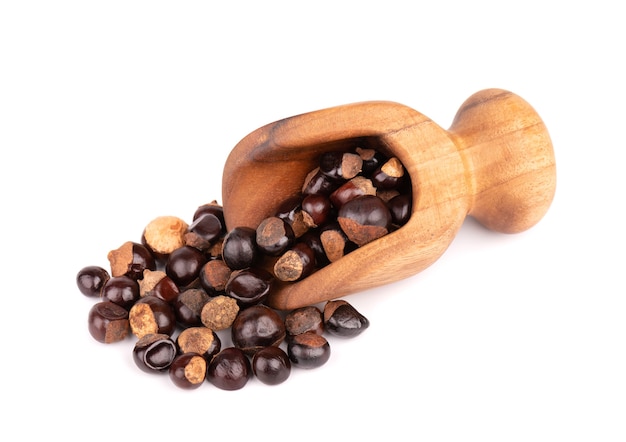 Graines de guarana en cuillère en bois, isolé sur une surface blanche