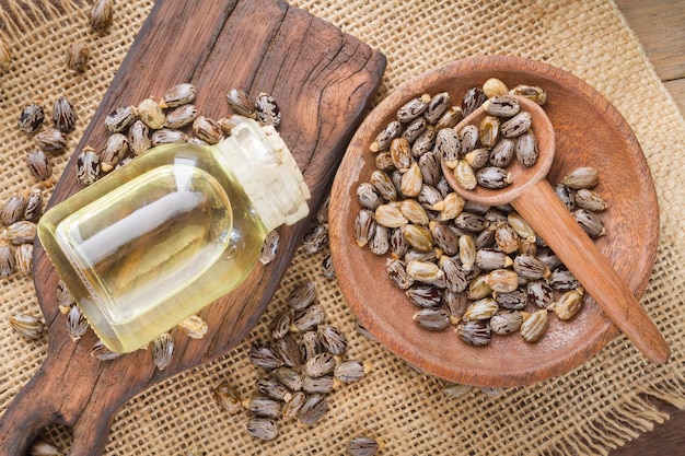 Graines et huile de ricin sur la table en bois Ricinus communis