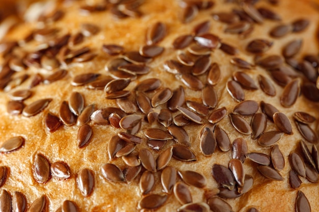 Graines de lin en gros plan saupoudrées sur du pain et des produits de boulangerie