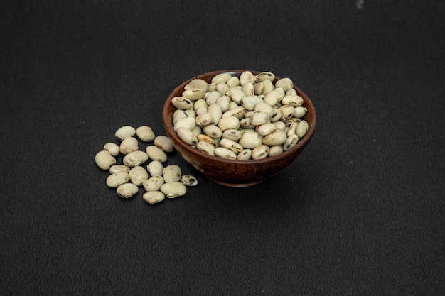 Graines de mucuna pruriens blanc d'herbes indiennes ou graines de Safed Konch dans un bol