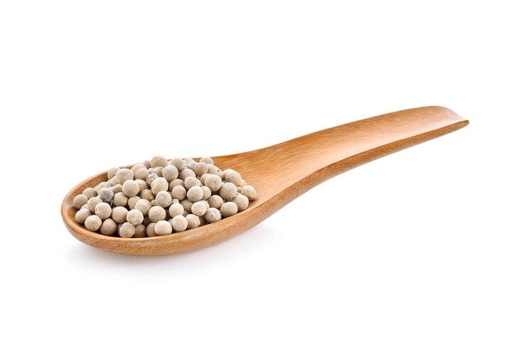 Graines de poivre dans une cuillère en bois