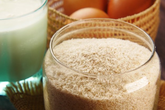 graines de psyllium dans un récipient en verre sur table