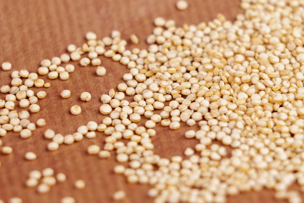 Des graines de quinoa biologique sur fond de papier brun en gros plan