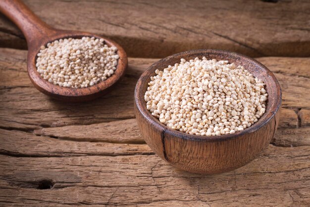 Graines de quinoa dans un bol sur bois rustique