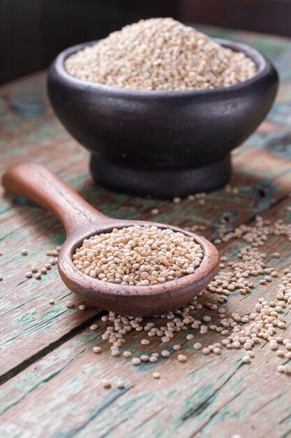 Graines de quinoa dans un bol sur bois rustique