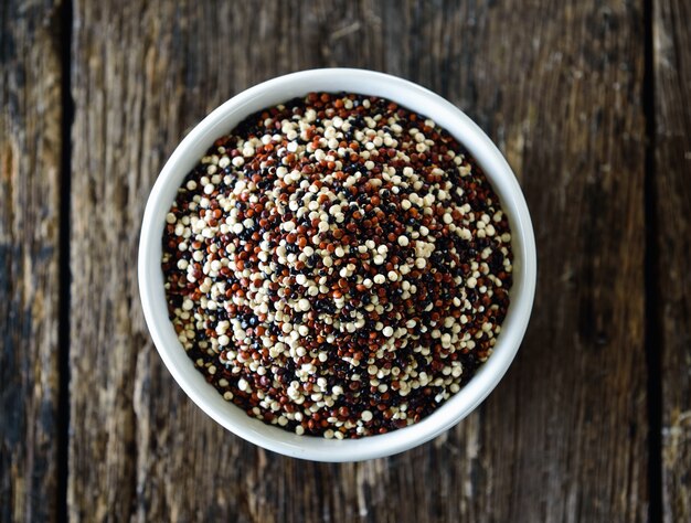 Graines de quinoa dans un bol sur bois