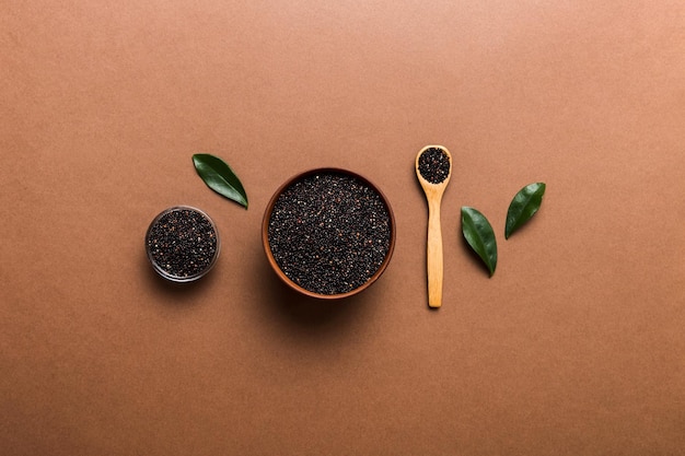 Graines de quinoa dans un bol et une cuillère sur fond coloré Kinwa sain dans un petit bol Superaliment sain