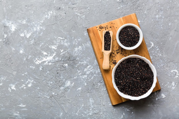 Graines de quinoa dans un bol et une cuillère sur fond coloré Kinwa sain dans un petit bol Superaliment sain