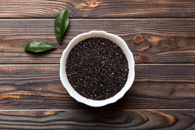 Graines de quinoa dans un bol sur fond coloré Kinwa sain dans un petit bol Superaliment sain