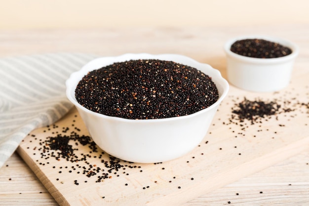 Graines de quinoa dans un bol sur fond coloré Kinwa sain dans un petit bol Superaliment sain