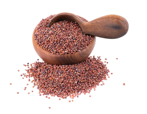 Graines de quinoa rouge dans un bol en bois et une cuillère isolé sur fond blanc